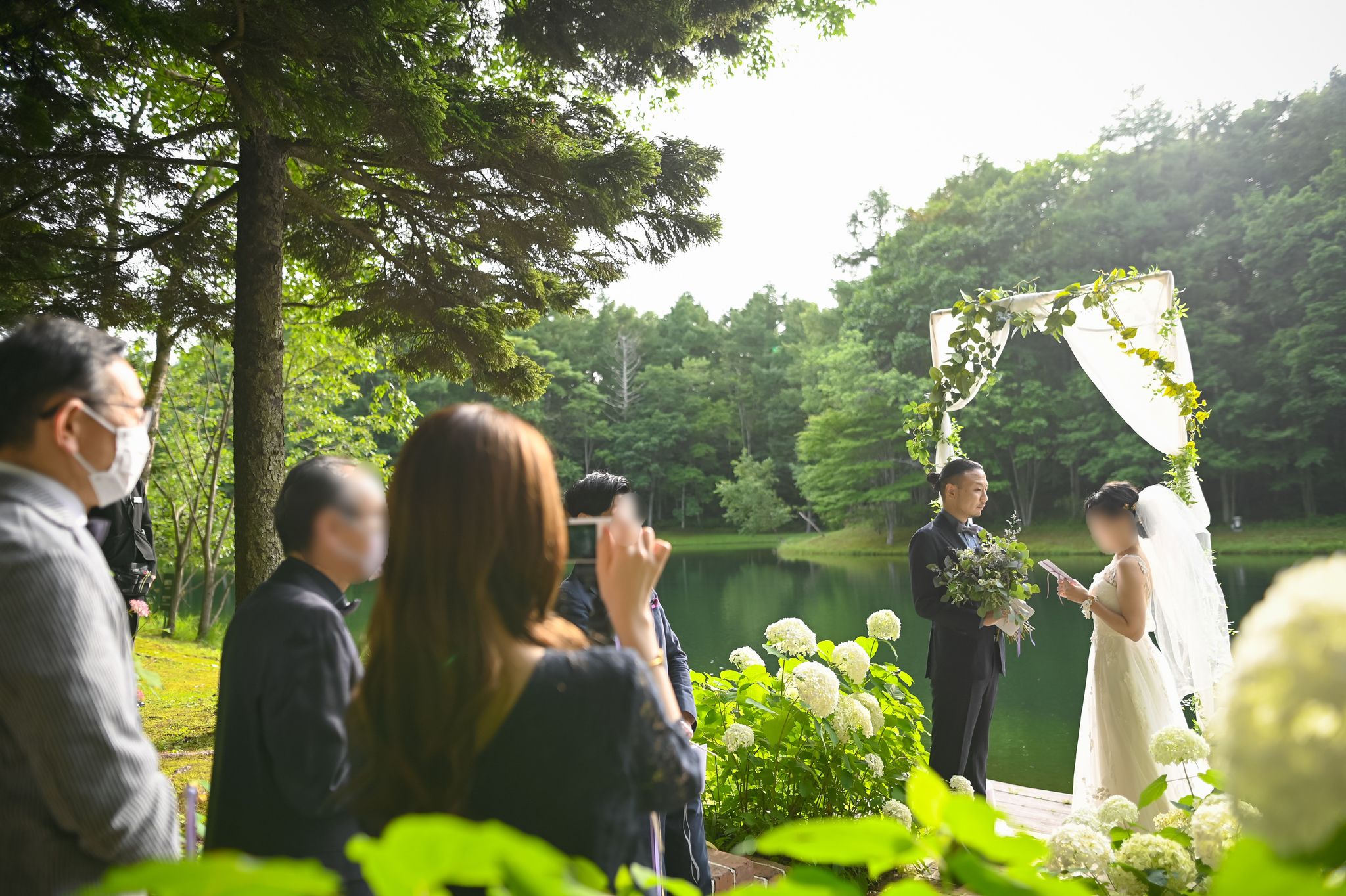 自然に咲く白い紫陽花を装飾に、森の水辺にアーチを立てた